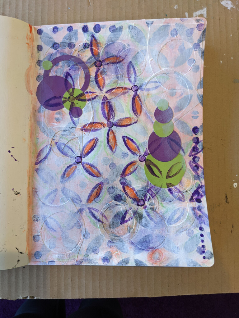 Image of a page in my art journal with a stenciled design and circles of paper