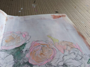 Close up of art journal - sketched flowers, painted pink with white background