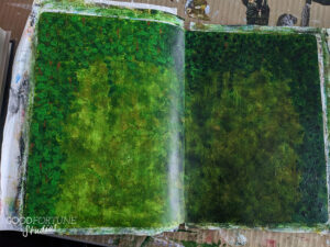 Image of the final layers of green, with a lighter left and darker right, framed around with leaves