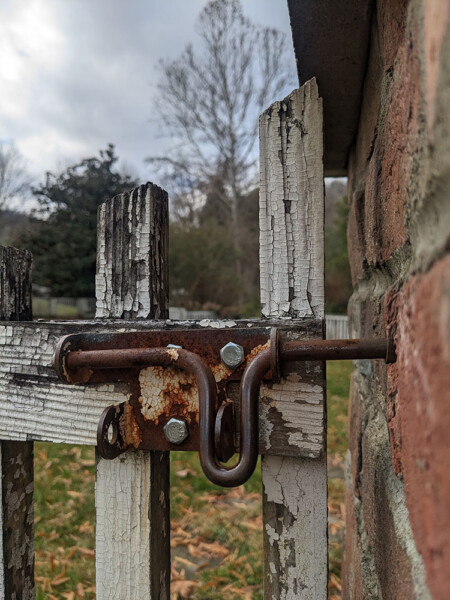 white weathered gate with rusty latch